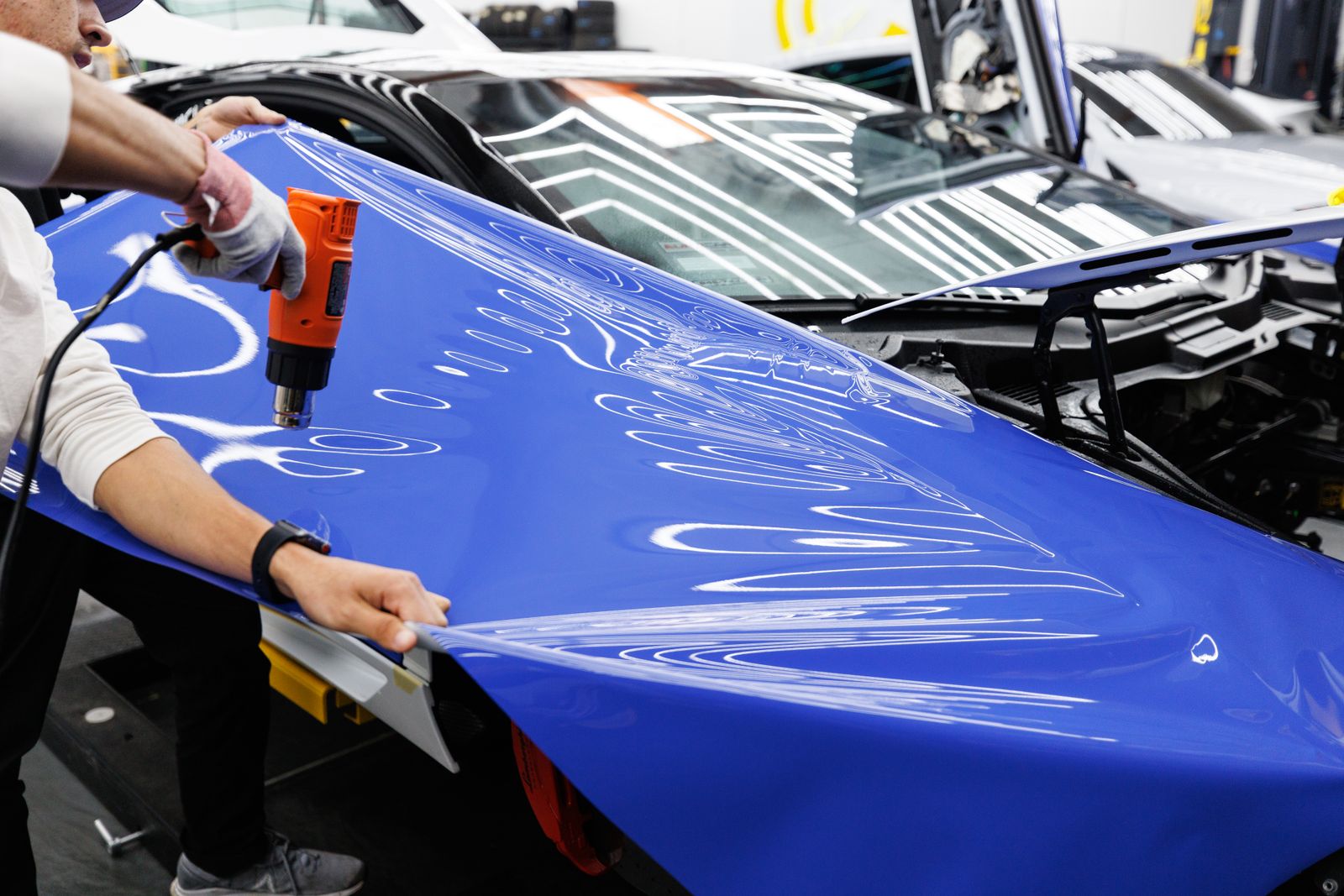 Installer heat-setting paint protection film on a car panel