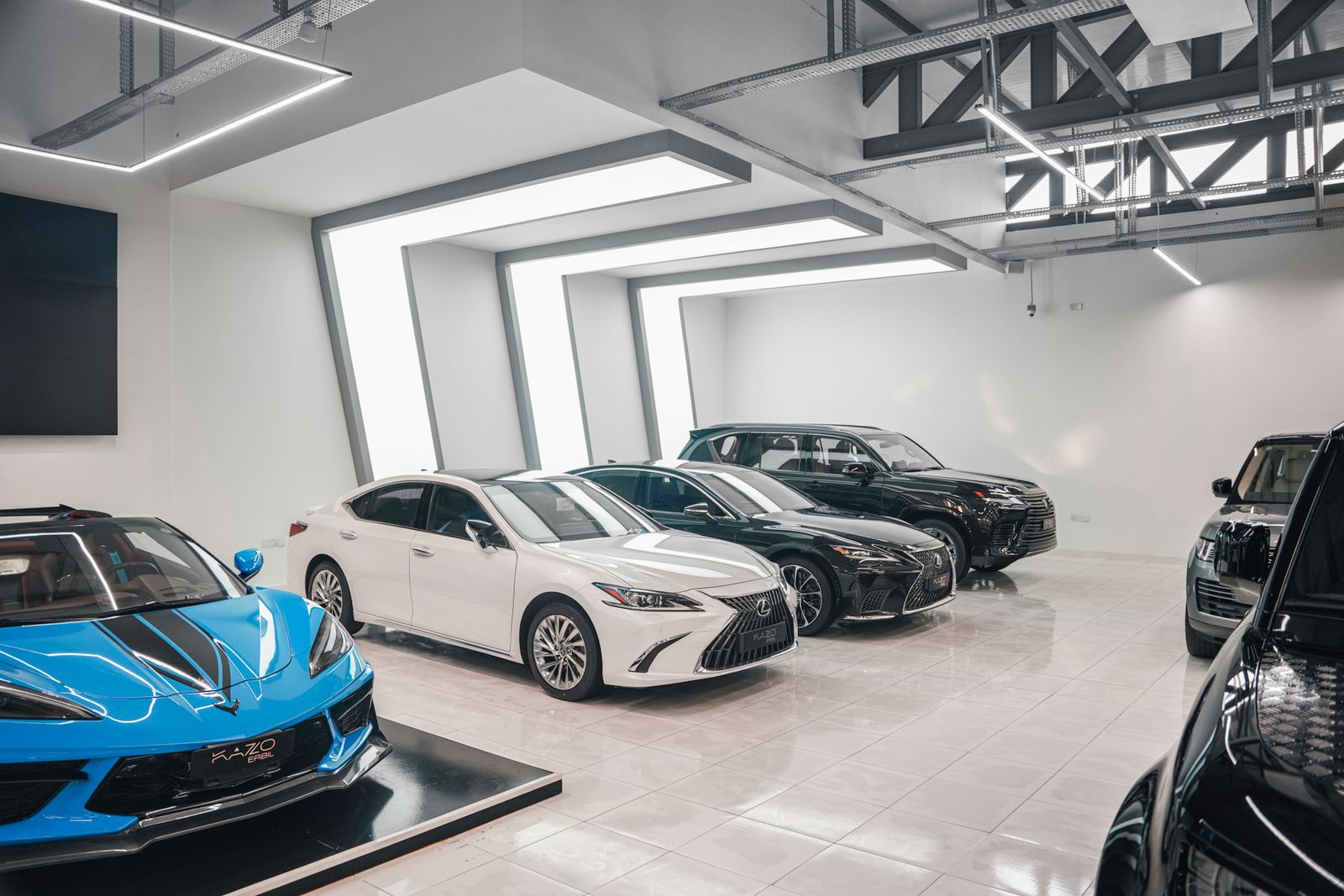 Clean, well-lit detailing bay with cars ready for protection work